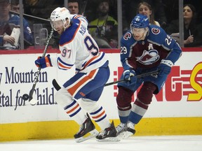 Edmonton Oilers' Connor McDavid collects the puck as Colorado Avalanche centre Nathan MacKinnon pursues.