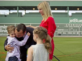 Boston Red Sox pitcher Tim Wakefield hugs his son, Trevor, 7, as his wife, Stacy, right, and daughter, Brianna, 6, look on after Wakefield announced his retirement in 2012.