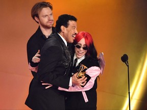 Billie Eilish and Finneas O'Connell accept the Song of the Year award from Lionel Ritchie.