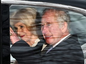 King Charles and Queen Camilla wave as they leave by car from Clarence House in London on February 6, 2024. (Photo by HENRY NICHOLLS/AFP via Getty Images)