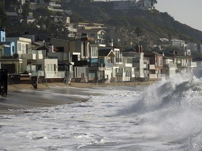 Waves break near beach homes in Malibu, Calif., on Dec. 28, 2023.