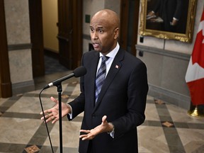 International Development Minister Ahmed Hussen speaks in the foyer of the House of Commons before question period on Parliament Hill in Ottawa, Thursday, Feb. 15, 2024.