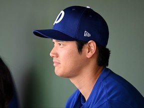 Shohei Ohtani #17 of the Los Angeles Dodgers looks on from the dugout against the Texas Rangers during a spring training game at Surprise Stadium on February 28, 2024 in Surprise, Arizona. (Photo by Norm Hall/Getty Images)