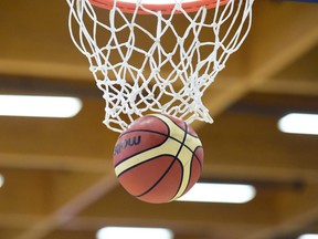 A basketball going through a net.