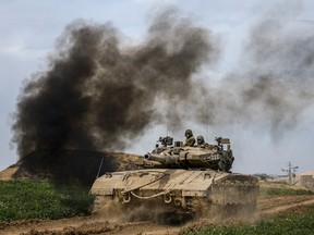 Israeli soldiers drive a tank