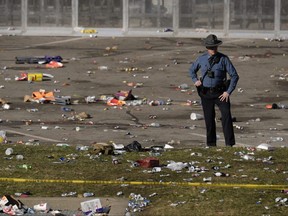 A law enforcement officer looks around the scene following a shooting at the Kansas City Chiefs NFL football Super Bowl celebration in Kansas City, Mo., Wednesday, Feb. 14, 2024.