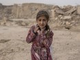 An Afghan girl carries donated aid to her tent