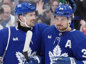 Maple Leafs forward Auston Matthews (right) is congratulated by teammate Simon Benoit after scoring his third goal against the Ducks during second period NHL action in Toronto, Saturday, Feb. 17, 2024.
