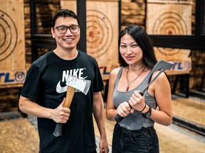Couple on date posing with axes at Bad Axe Throwing in Mississauga, Ont.