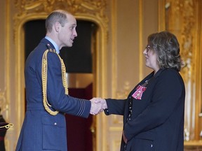 Prince William, the Prince of Wales, left, awards Karen Steen, Executive Head Teacher, Falkland Islands Schools, with the Commander of the Order of the British Empire, at Windsor Castle, Windsor, England, Wednesday, Feb. 7, 2024. The honour recognizes services to education in the Falkland Islands. (Yui Mok/PA via AP)