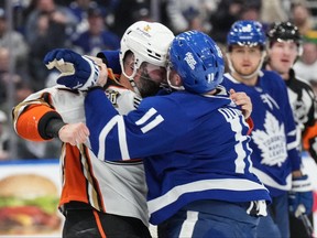 Anaheim Ducks' Radko Gudas, left, fights with Toronto Maple Leafs' Max Domi during first period NHL hockey action in Toronto, on Saturday, February 17, 2024. THE CANADIAN PRESS/Chris Young
