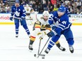 Maple Leafs' Morgan Rielly (right) battles for the puck with Vegas Golden Knights' Michael Amadio during the first period in Toronto, on Tuesday, Feb. 27, 2024.