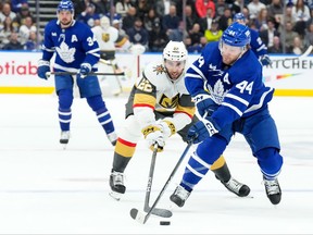 Maple Leafs' Morgan Rielly (right) battles for the puck with Vegas Golden Knights' Michael Amadio during the first period in Toronto, on Tuesday, Feb. 27, 2024.