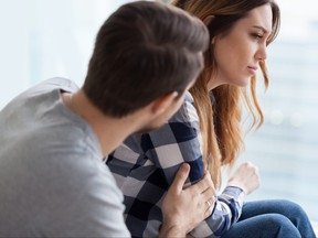 Caring man comforting upset wife after fight