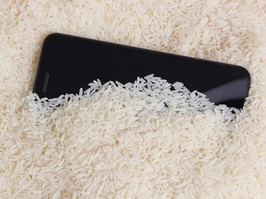 Smartphone in bowl of white rice to remove water and moisture
