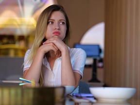 Young woman sitting in restaurant alone waiting for a date.