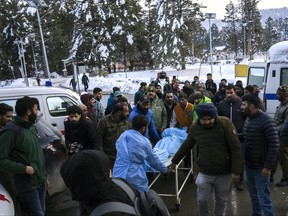 A paramedic and volunteers transport the body of a Russian skier to a hospital in Tangmarg, near Gulmarg, a popular skiing destination in the Indian controlled Kashmir, Thursday, Feb. 22, 2024.