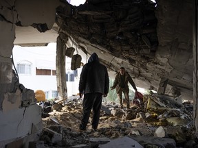 Palestinians check destruction after an Israeli strike