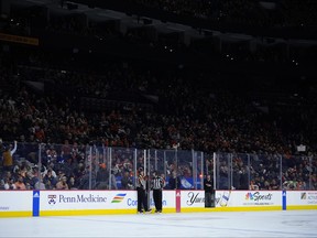 Officials talk during a partial power outage in the first period of an NHL hockey game between the Philadelphia Flyers and the Tampa Bay Lightning, Tuesday, Feb. 27, 2024, in Philadelphia.