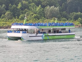 People in blue ponchos ride the Maid of the Mist on the Niagara River.
