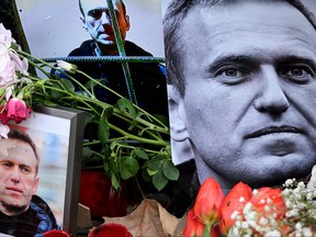 Flowers are seen placed around portraits of late Russian opposition leader Alexei Navalny, who died in a Russian Arctic prison, at a makeshift memorial in front of the former Russian consulate in Frankfurt am Main, western Germany, on Feb. 23, 2024.