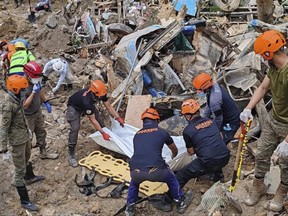 In this Feb. 9, 2024 handout photo from Municipality of Monkayo, rescuers recover bodies at the landslide-hit village of Maco in Davao de Oro province, southern Philippines.