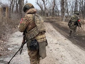In this photo released by Russian Defence Ministry Press Service on Monday, Feb. 19, 2024, two soldiers of the Russian military engineering units eliminate the mine danger in the city of Avdiivka, eastern Ukraine.