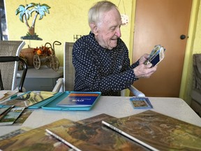 Tom Henschel looks over some of his Super Bowl memorabilia at his home Thursday, Jan. 25, 2024, in Tampa, Fla. Three football fans in their 80s are keeping their membership in the “never missed a Super Bowl” club. (AP Photo/Chris O’Meara)