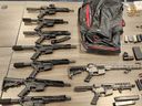 Some of the guns seized during Project SAXOM, a cross-border operation that resulted in the discovery of 274 illegal firearms and a large quantity of drugs, police announced Thursday, February 22, 2024, in Orillia, Ontario.