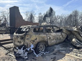 A burned car sits near the ruins of a home outside of Canadian, Texas, Wednesday, Feb. 28, 2024 after a fast-moving wildfire burned through the Texas Panhandle.