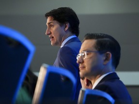 Prime Minister Justin Trudeau, left, and Conservative Leader Pierre Poilievre take part in the National Prayer Breakfast in Ottawa, May 30, 2023.