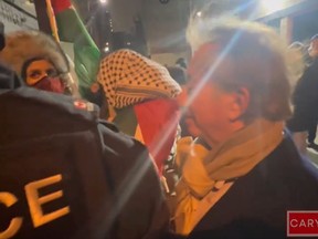 Mark Breslin, the owner of Yuk Yuk’s Comedy Club, is escorted by police into his club, which was targeted by pro-Palestinian protesters on Wednesday, Jan. 31, 2024.