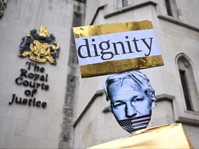 Demonstrators hold placards as they protest outside of the Royal Courts of Justice, Britain's High Court, in central London on Feb. 20, 2024, as the high court hears the final U.K. appeal by WikiLeaks founder Julian Assange against his extradition to the U.S.