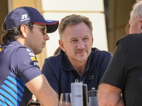 Red Bull team principal Christian Horner, centre, chats with Red Bull driver Sergio Perez of Mexico, left, and Helmut Marko, director of the Red Bull Formula One teams, right, at the pits during Formula One pre season test at the Bahrain International Circuit in Sakhir, Bahrain, Wednesday, Feb. 21, 2024.