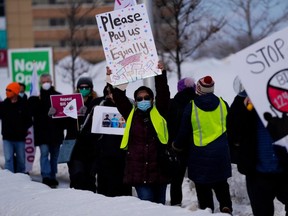 Nurses and their supporters protest against Ontario's Bill 124 on the sidewalk in front of the constituency office of PC MPP Jeremy Roberts, who represents Ottawa West-Nepean in Ottawa, on March 4, 2022. (The Canadian Press)