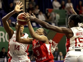 Kayla Alexander, left, and Laeticia Amihere, right, of Canada in action against Mawuli Stephanie of Japan during the women' basketball Olympic qualifying tournament third round match between Canada and Japan in Sopron, Hungary, Sunday, Feb. 11, 2024.