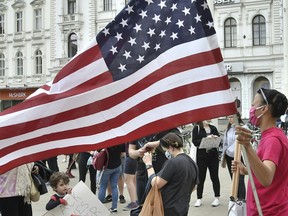 A protestor holds the U.S. flag during a Black Lives Matter march in Vienna, Austria, on June 4, 2020, in solidarity with protests raging across the United States over the death of George Floyd, an unarmed black man who died during an arrest on May 25.
