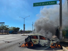 A burning car is seen on the street