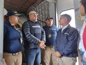 In this photo released by the Colombian Immigration agency, migration officials meet former Colombian paramilitary leader, Salvatore Mancuso, at the gate of the plane at El Dorado International Airport in Bogota, Colombia, Tuesday, Feb. 27, 2024, upon arrival from the U.S. which deported him after he served time for drug trafficking. (Colombian Immigration Agency via AP)