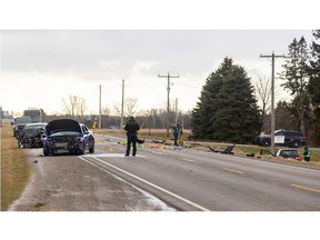 OPP investigators survey damaged vehicles and debris on Highbury Avenue between 10 Mile Road and Ilderton Road on Tuesday, Feb. 13, 2024. Three vehicles collided at about 5:25 a.m., killing two people and injuring eight others, Middlesex OPP said. (Mike Hensen/The London Free Press)