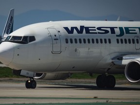 Pilots taxi a WestJet Boeing 737-700 aircraft to the runway for departure from Vancouver International Airport, in Richmond, B.C., on Friday, May 19, 2023.
