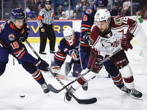 Peterborough Petes forward Connor Lockhart, right, chases the puck with Kamloops Blazers defenceman Harrison Brunicke, left, as goalie Dylan Ernst, centre, looks on during first period Memorial Cup hockey action in Kamloops, B.C., Thursday, June 1, 2023. Lockhart, now with the Oshawa Generals, has been suspended indefinitely by the team and the Ontario Hockey League after it was learned he is under investigation by Durham Regional Police.