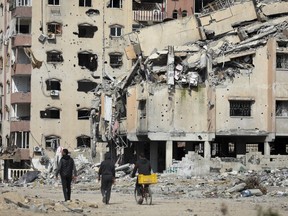Palestinians walk through the destruction