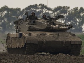 Israeli soldiers drive a tanks near the Gaza Strip border, in southern Israel, Monday, Feb. 19, 2024.