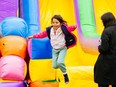 Child jumping from inflatable slides at Kids Fest TO.