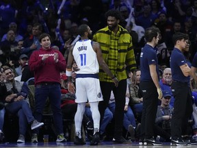Philadelphia 76ers' Joel Embiid, center right, and Dallas Mavericks' Kyrie Irving (11) meet during the second half of an NBA basketball game, Monday, Feb. 5, 2024, in Philadelphia.