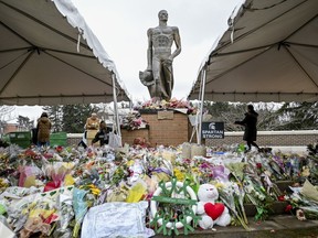 Volunteers work to clean up the memorial site at the Sparty statue