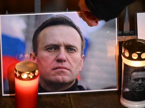 Candles and a photo of Russian opposition leader Alexei Navalny are left at a makeshift memorial as people demonstrate and pay their respect following his death in prison, in front of former Russian consulate in Frankfurt, western Germany on Feb. 16, 2024.