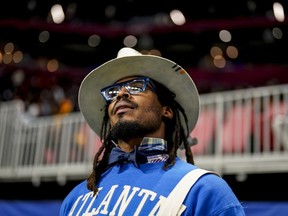 NFL football player Cam Newton watches play between Howard and Florida A&M during the first half of an NCAA Celebration Bowl football game.