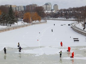 NCC crews flood the ice near the Flora Footbridge on the Rideau Canal in Ottawa Friday.